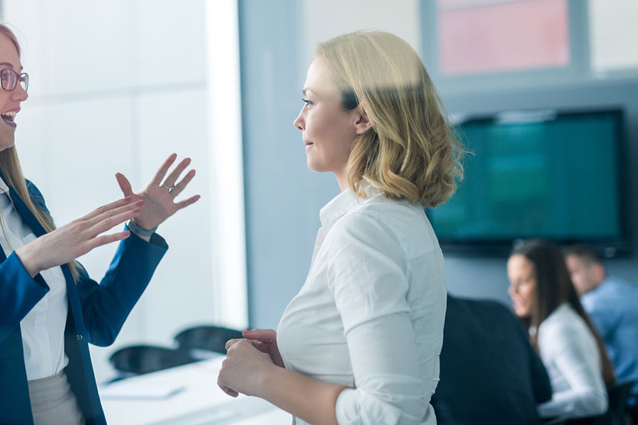 two woman talking in meeting room