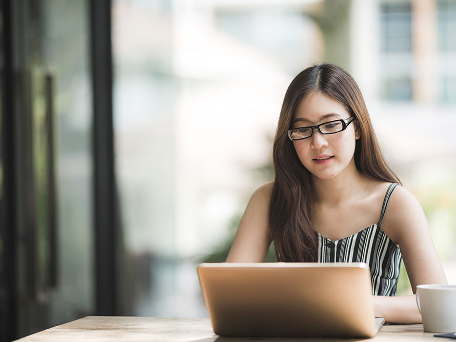 woman at a coffee shop working on a her laptop